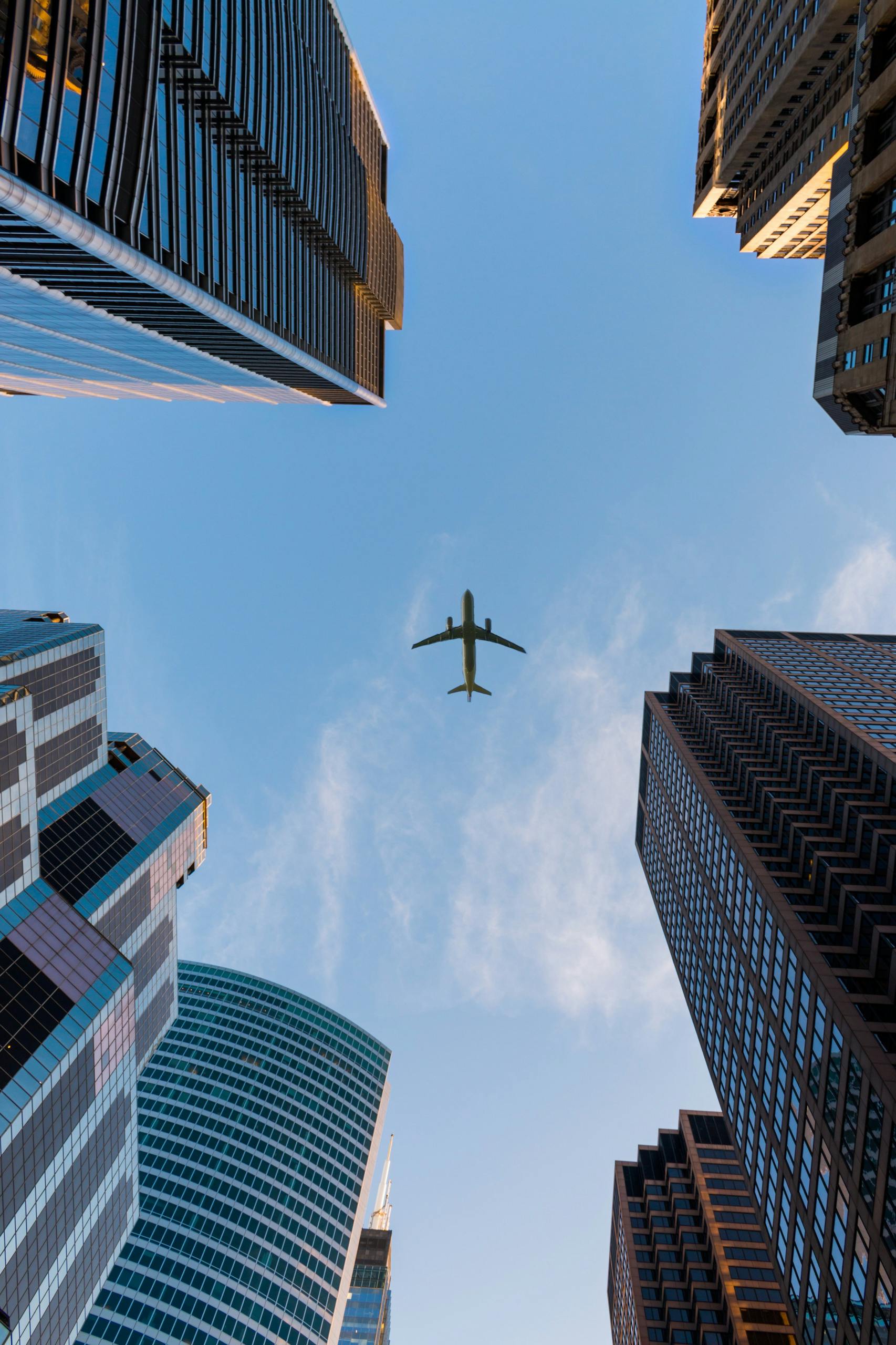 Airplane flying over city buildings